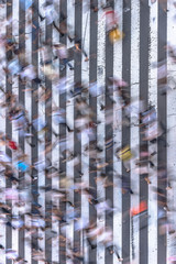Aerial view of a Japanese pedestrian passage in Tokyo painted with white stripes on the black asphalt used by the traffic of cars and the footsteps of passersby.