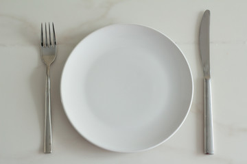 white plate, fork and knife.