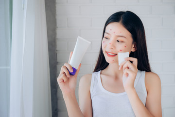 Young Beauty Asian Woman Cleaning Face with Cotton and Cleansing foam Skincare for Reduce acne problems Her Smile and Happy Morning in White Bedroom.