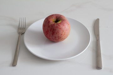 red apple on a white plate, diet.