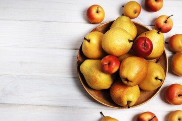Yellow sweet pears and apple on a white wooden background. Copy space. Design elements.