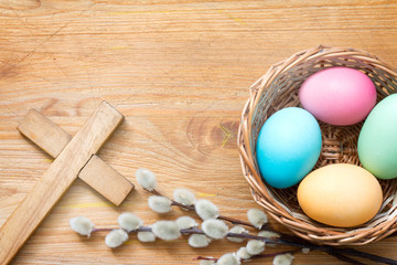 Easter eggs and cross on abstract wooden spring background
