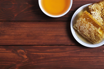 Traditional medicine. Honey and bee honeycombs. Ginger and lemon on the wooden table. Place for text. Top view.