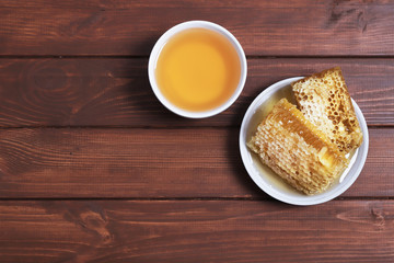 Traditional medicine. Honey and bee honeycombs. Ginger and lemon on the wooden table. Place for text. Top view.