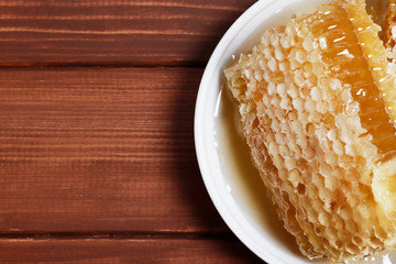 Traditional medicine. Honey and bee honeycombs. Ginger and lemon on the wooden table. Place for text. Top view.