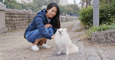 Woman go out with Pomeranian dog