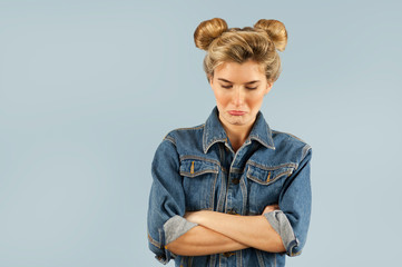 Young beautiful strongly emotional girl shows different gestures on an isolated blue background....