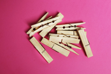 Wooden clothespins on a pink background. Place for text. Top view, flat lay