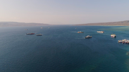 Aerial view ferry port gilimanuk with ferry boats, vehicles. Ferries transport vehicles and passengers in port. Port for departure from Bali to the island of Java.