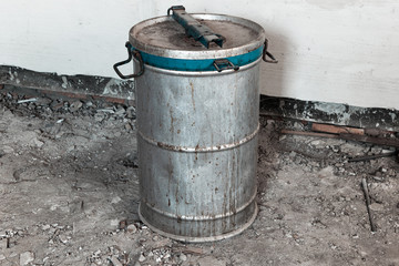 Old metal barrel with an unknown substance inside. Barrel with blue border