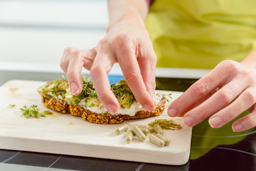 Close-up of woman preparing sandwich in the kitchen