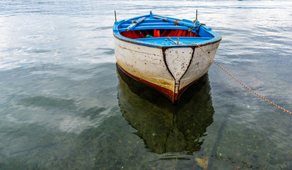 Obraz premium Small Old Fishing Boat in a Harbor on the Southern Mediterranean Coast of Italy