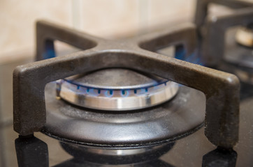 Modern kitchen stove cook with blue flames burning.