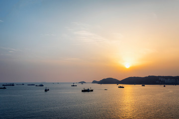 Obraz premium The setting sun on the sea, ships, mountains, a beautiful evening landscape
