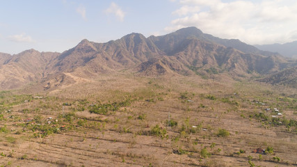 aerial view agricultural land and mountains in countryside. mountain range with high cliffs mountain slopes covered with vegetation bali, indonesia