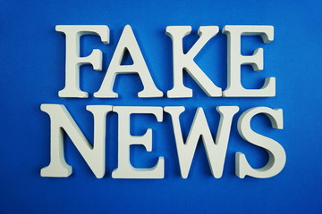Fake News word alphabet letters on blue background