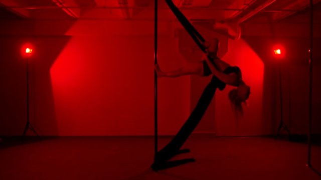 Adult sexy woman dancing dance in an intimate setting. Silhouette of a sexy woman dancing on red background. Pole dance from an old woman