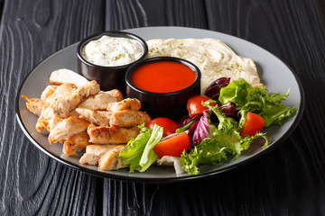 shawarma bowl with chicken, hummus, fresh vegetables salad and sauce close-up. horizontal