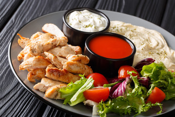 Mediterranean Chicken Shawarma Bowl with hummus, vegetables salad and sauce close-up. horizontal
