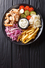 Chicken shawarma with vegetables and sauce serving on a plate close-up. Vertical top view