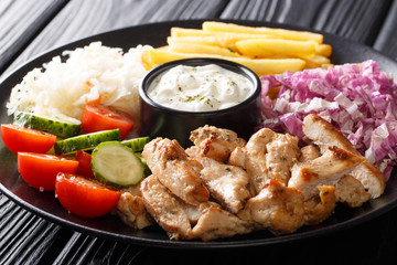 Chicken shawarma with vegetables and sauce serving on a plate close-up. horizontal