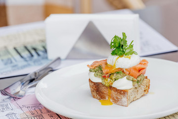 Toast with guacamole, salmon and poached egg.