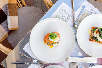Breakfast table: toast with guacamole, salmon and poached egg and eggs benedict with brioche, bacon and spinach.