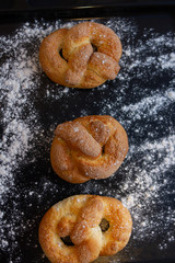 buns with sugar on a black background with flour
