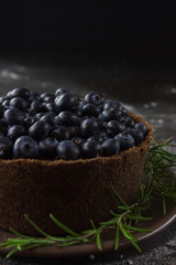 Blueberry vegan cheesecake. Dark photo on black background
