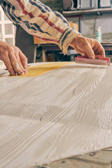 Artist using paint brush for making artificial wood texture.