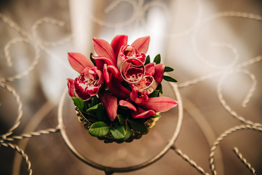 wedding rings lie on delicate red flowers