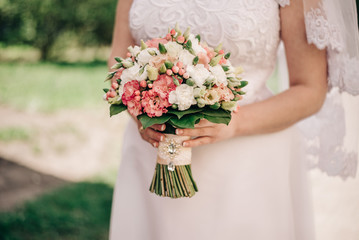 Obraz na płótnie Canvas bride holds a bouquet of roses