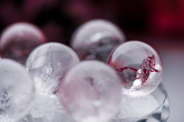 Fortune telling. Love, money, luck, success. Macro shot of transparent crystal ball with orange ornaments on glass pad with sun reflections in it