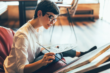 Beautiful young woman attending a painting workshop