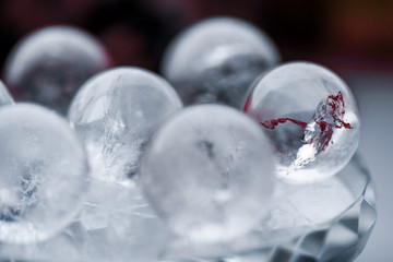 Fortune telling. Love, money, luck, success. Macro shot of transparent crystal ball with orange ornaments on glass pad with sun reflections in it