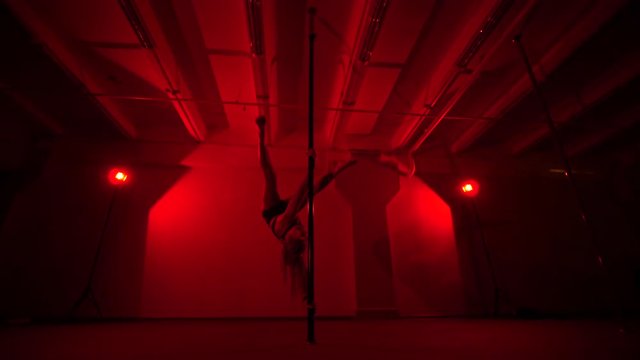 Adult sexy woman dancing dance in an intimate setting. Silhouette of a sexy woman dancing on red background. Pole dance from an old woman