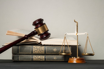 Law concept. Wooden judge gavel with law books ,scales of justice on table in a courtroom or...