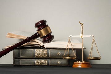 Law concept. Wooden judge gavel with law books ,scales of justice on table in a courtroom or enforcement office.