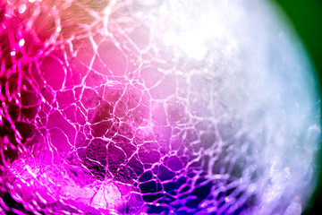 Macro shot of broken, cracked glass ball on colorful rainbow background. Glass reflecting light on sunny summer day. Future prediction, fortune telling in crystal ball. Abstract, esoteric background