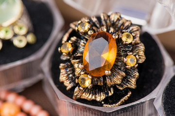 Macro shot of silver engagement ring in gift box on colorful, sparkling background. Ring made of yellow sapphire and citrine stone. Healing, natural crystals and powerful energy