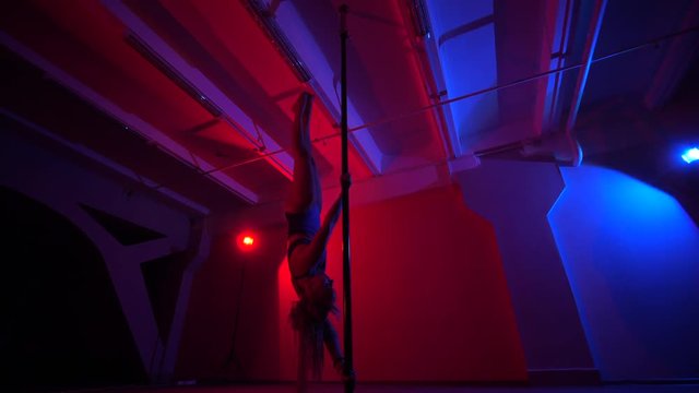 Adult sexy woman dancing dance in an intimate setting. Silhouette of a sexy woman dancing on red background. Pole dance from an old woman
