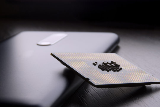 phone and processor chip lie on wooden table
