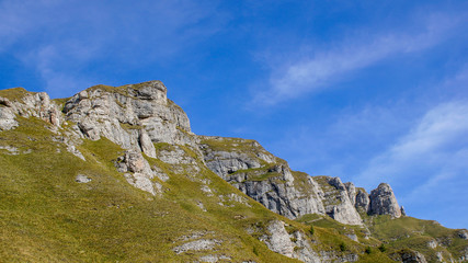 Tranquil mountain peaks landscape against a vibrant blue sky. Beautiful rock formations in Bucegi, Carpathians mountain range, Romania.