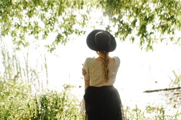 The young woman in the hat photographed from the behind.