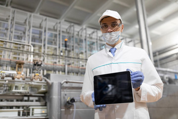 technologist shows a blank screen of the tablet at the dairy plant