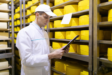 inspector makes notes in the sheet at the cheese warehouse