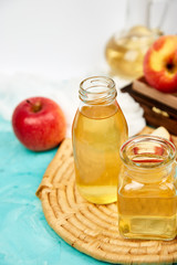 Glass Bottle of apple organic vinegar on blue background.
