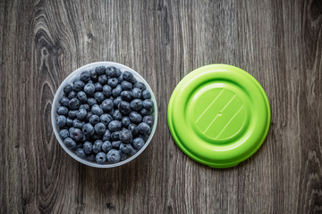 Ripe tasty blueberries and berries on a wooden table in a bowl