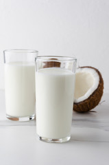 Glasses with fresh kefir,coconut,marble table.Vertical photo