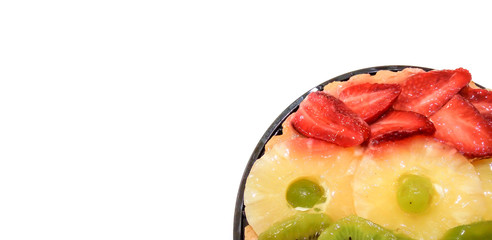 Fruit cake pie with oranges, kiwi, grapes, pineapple and strawberries closeup isolated on white background with place for text. view from above.